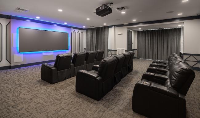 a room with a large screen and chairs